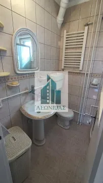 Smaller bathroom tiled with ceramic tiles featuring a sink, toilet bowl, and mirror. - image 14