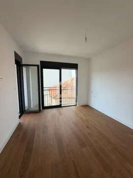 Prazna prostorija sa drvenim podom i izlazom na terasu. - image 10