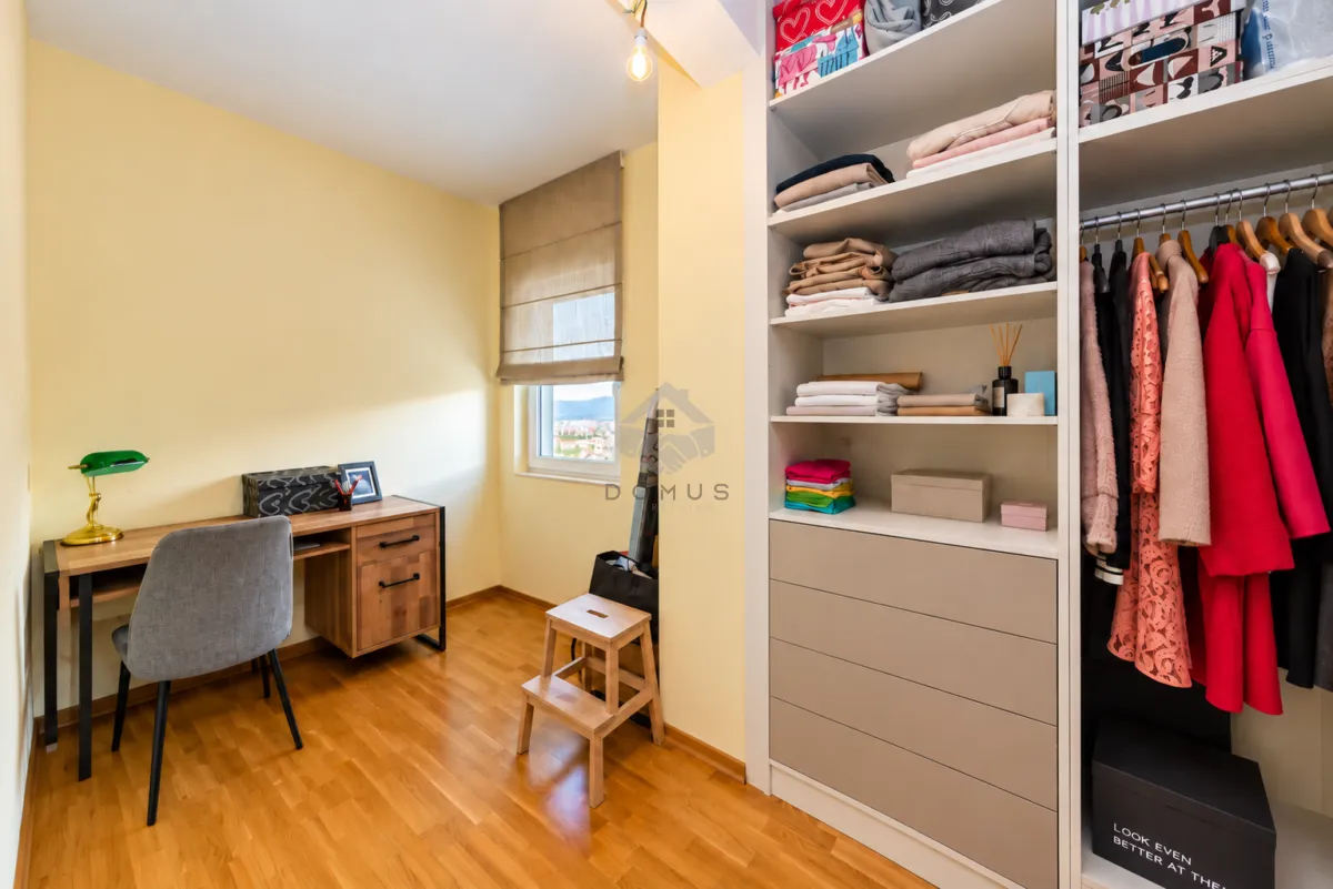 Small room with a desk and a large built-in wardrobe.