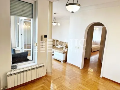 View from the hallway into a bright living room with parquet flooring. - image 18