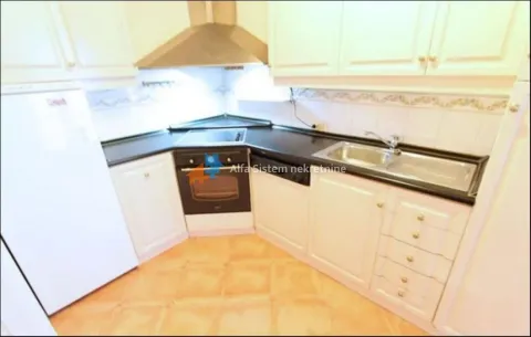 Kitchen with white cabinetry, built-in oven, and refrigerator. - image 13