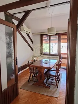 Dining area with a wooden table and chairs, parquet flooring, and access to the terrace. - image 8