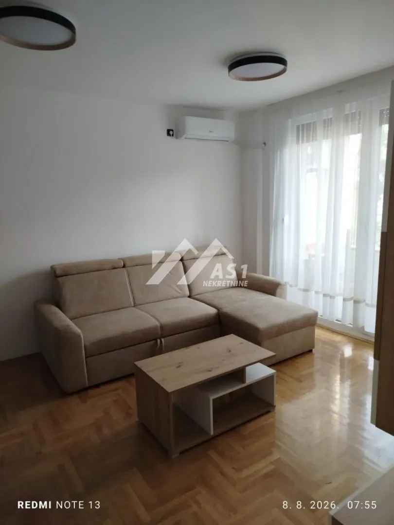 Dnevna soba sa ugaonom garniturom i stočićem.