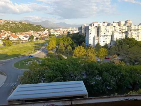 Pogled sa prozora na naselje, zelenilo i planine u daljini. - image 13