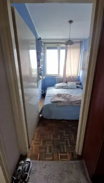 Pogled iz hodnika na malu spavaću sobu sa krevetom i prozorom. - image 10