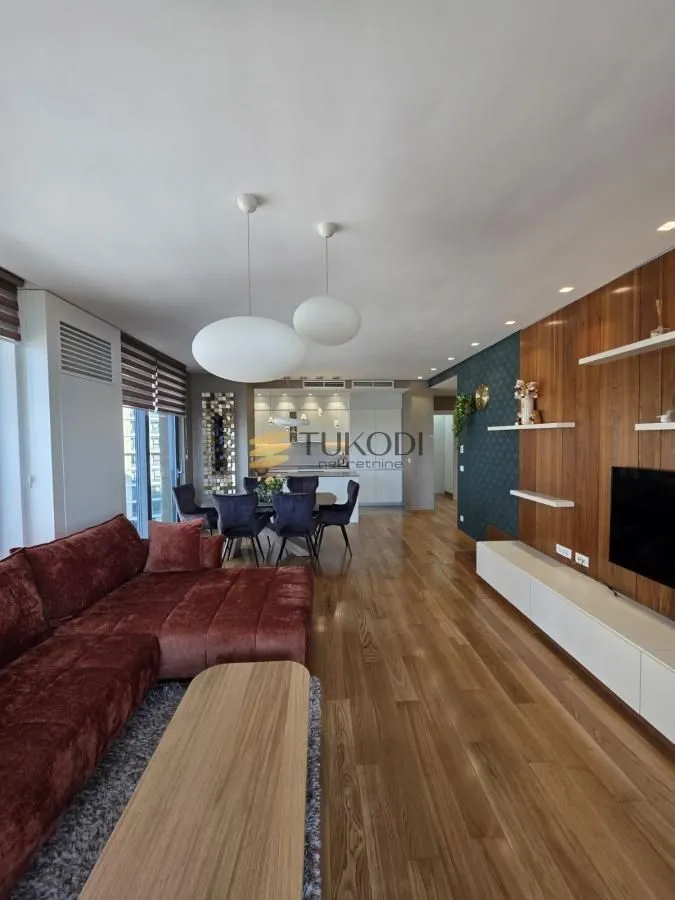 Spacious living room with a sofa set, dining area, and kitchen in the background.