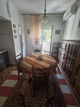 Dining area with a table, chairs, and a wooden cabinet in the apartment. - image 8