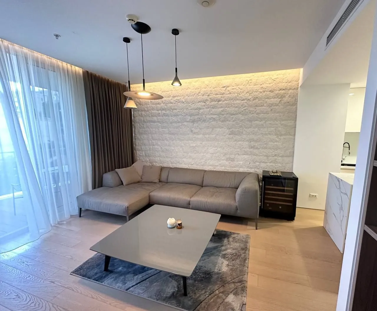 Modern living room with a sectional sofa and decorative lighting.
