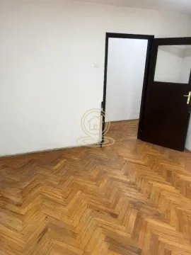 Prazna prostorija sa parketom i tamnim drvenim vratima. - image 4