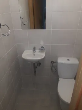 A small bathroom featuring a sink and a toilet. - image 10