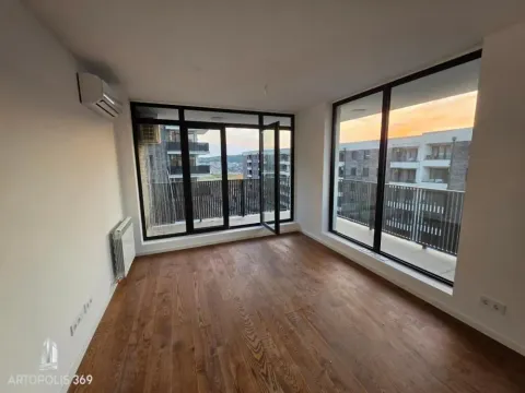 Empty room with wooden flooring, air conditioning and large glass surfaces leading to a terrace. - image 8