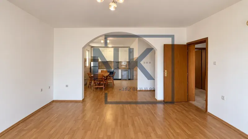 Empty living room with a view of the kitchen and dining area.