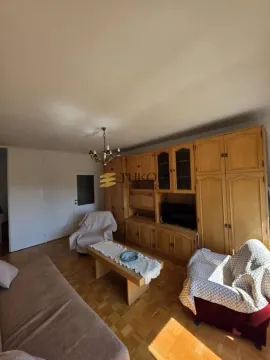 Dnevna soba sa garniturom i velikim drvenim ormarom. - image 3