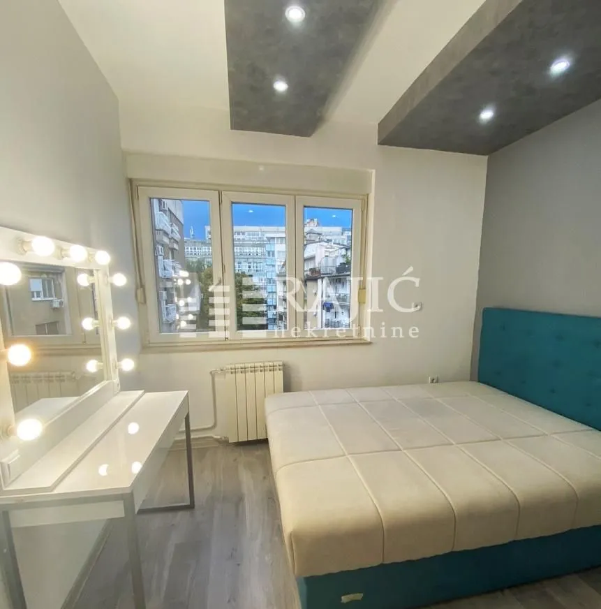 Furnished bedroom with a double bed and a vanity table.