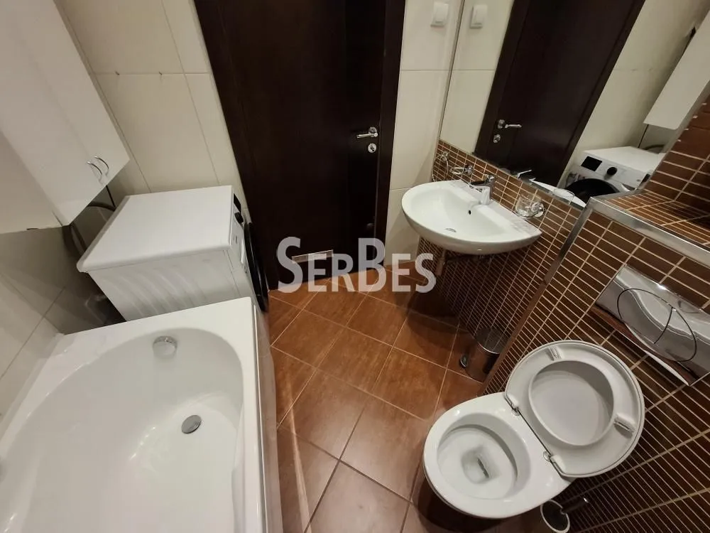 Kupatilo opremljeno kadom, umivaonikom, WC šoljom i veš mašinom.