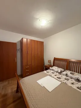 Namještena spavaća soba sa bračnim krevetom i drvenim ormarom. - image 8