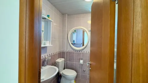 Manje kupatilo obloženo keramičkim pločicama sa umivaonikom i šoljom. - image 8