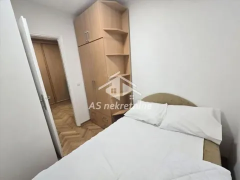 Smaller bedroom with a bed and a wooden wardrobe. - image 8