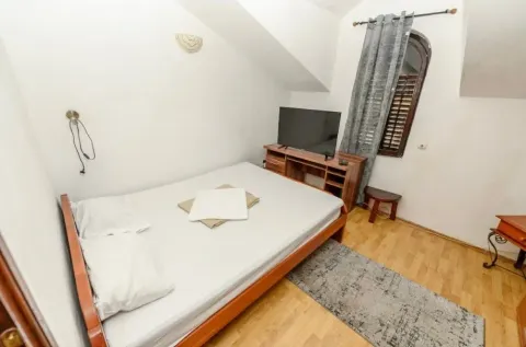 Small bedroom with a double bed, TV, and sloping ceiling. - image 10