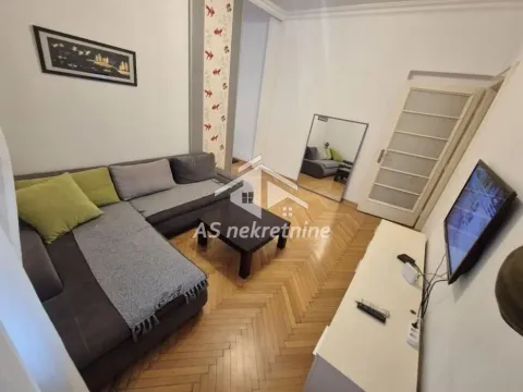 Living room with a sofa, coffee table, and television. - image 4