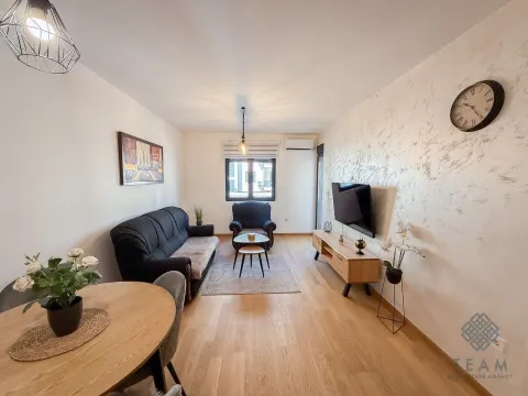 Living room with a sofa, TV, and dining table. - image 3
