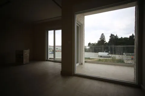 Prazna, neosvijetljena prostorija sa velikim staklenim vratima koja vode na balkon. - image 6