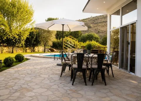 Terrace with a dining table overlooking the pool and yard. - image 8
