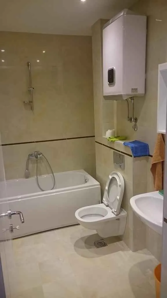 Moderno kupatilo sa kadom, toaletom, umivaonikom i bojlerom.