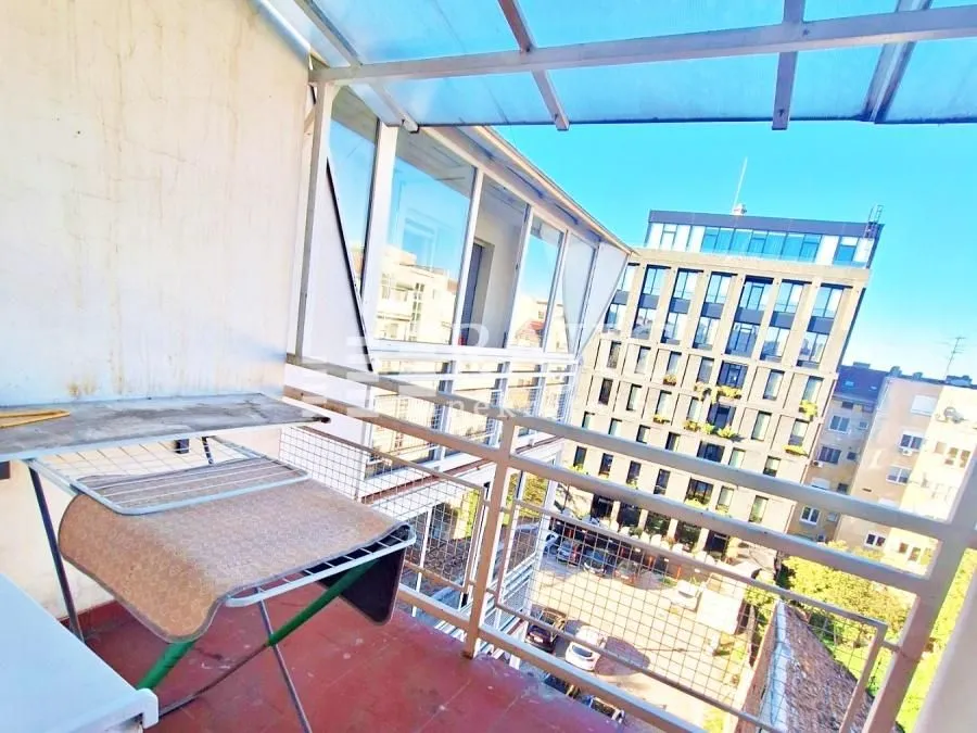 Covered balcony with a drying rack and a city view.