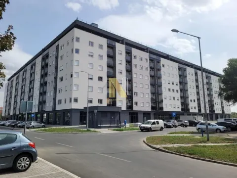Exterior view of a modern apartment building with parking and a street in front. - image 2