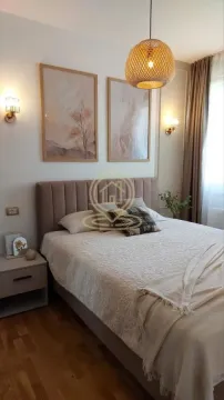 Nameštena spavaća soba sa bračnim krevetom, noćnim stočićem i dekorativnim osvetljenjem. - image 8