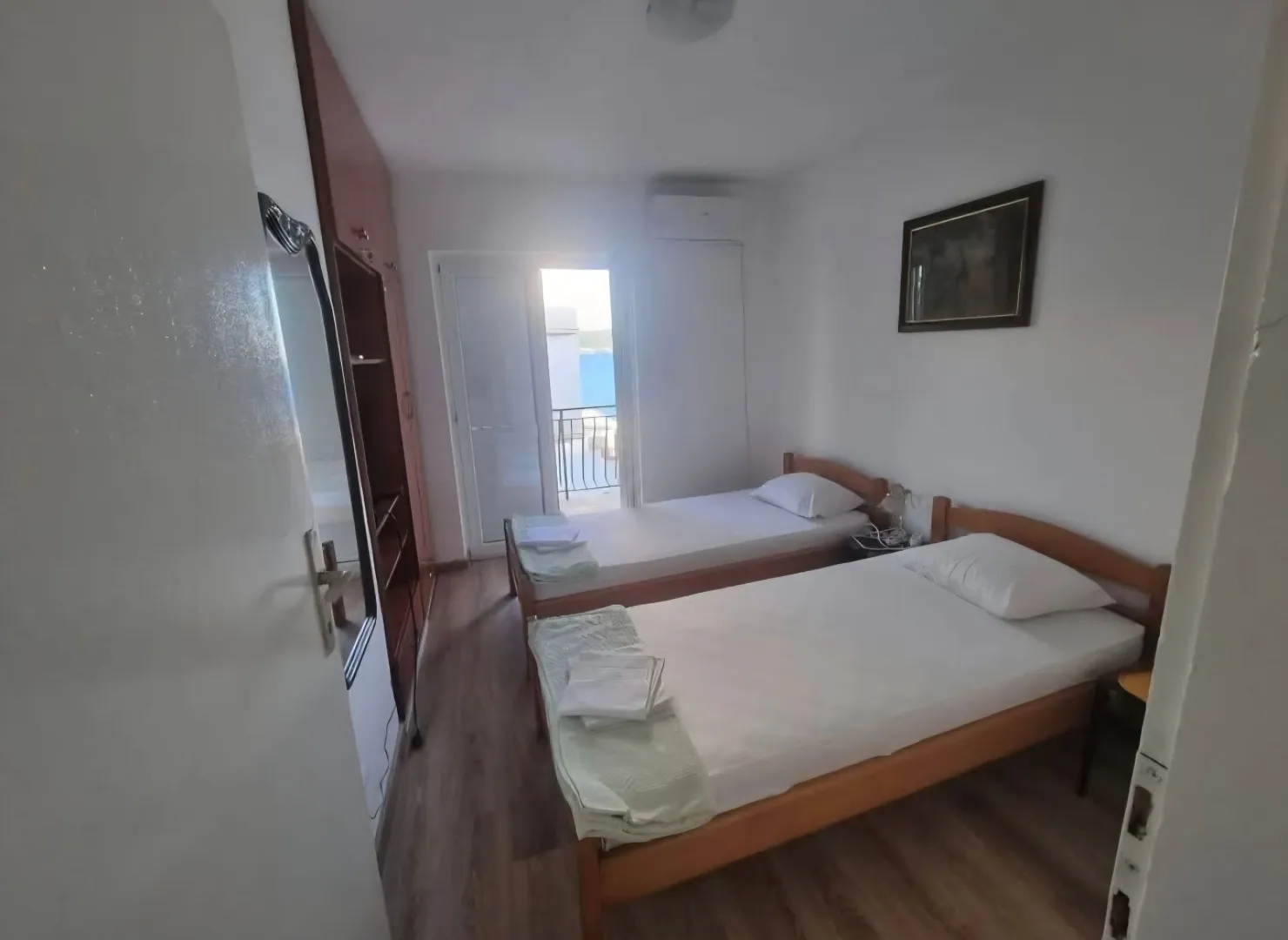 Spavaća soba sa dva odvojena kreveta i izlazom na terasu.