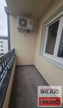 Small covered balcony with an outdoor air conditioning unit and tiled flooring. - image 8