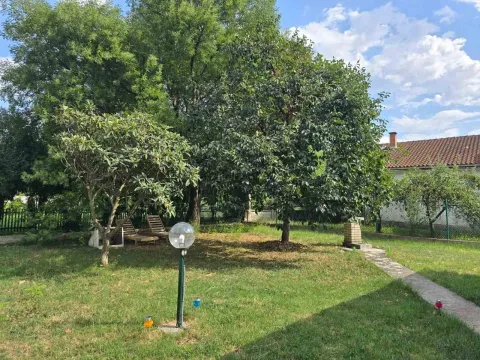 Uređeno dvorište sa zelenim travnjakom, drvećem i pješačkom stazom. - image 7