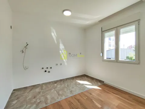 Empty room with a window, white walls, and a combination of ceramic tiles and parquet flooring. - image 2