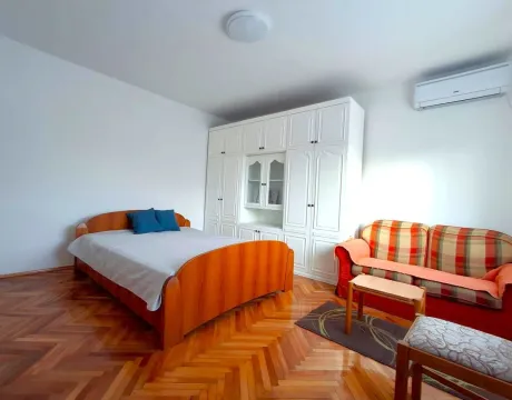 Bright bedroom with a wooden bed, white wardrobe, and parquet floor. - image 10