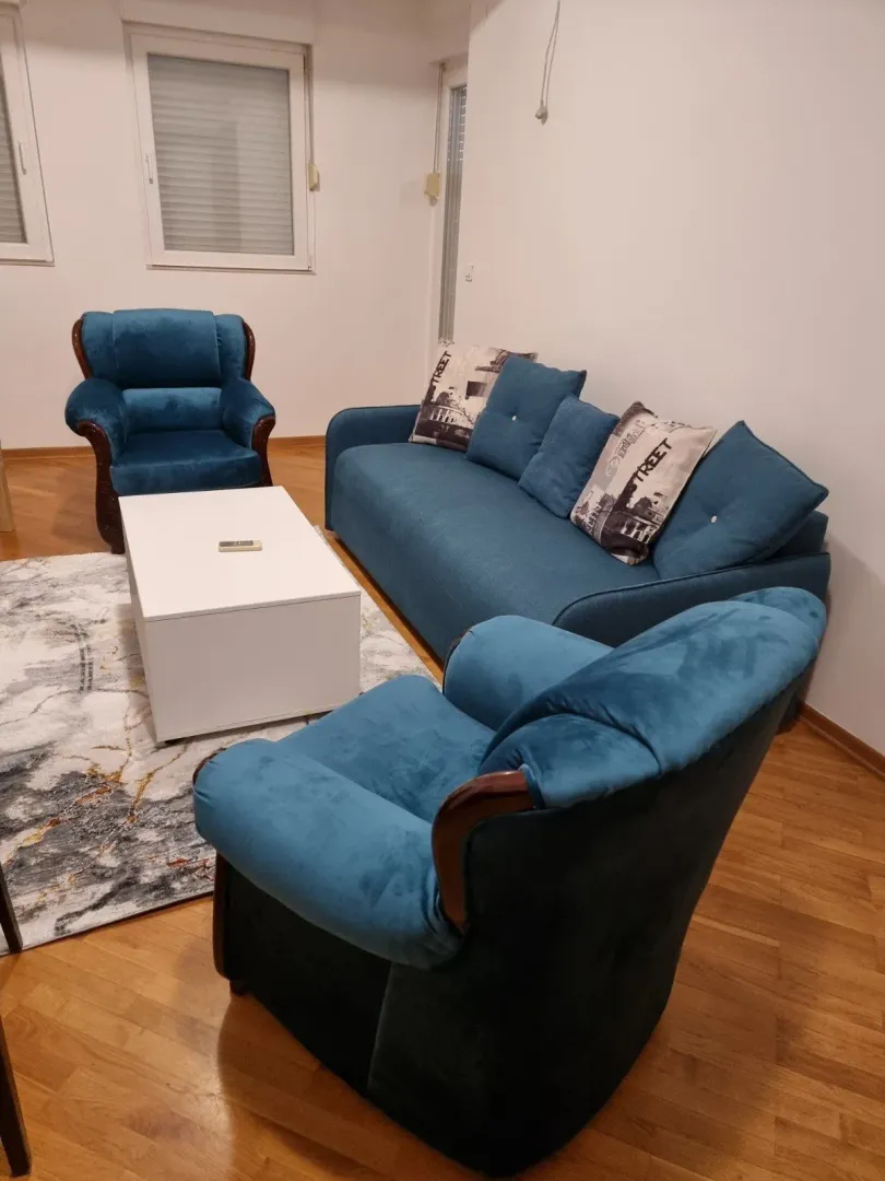 Living room with blue seating and a white table.