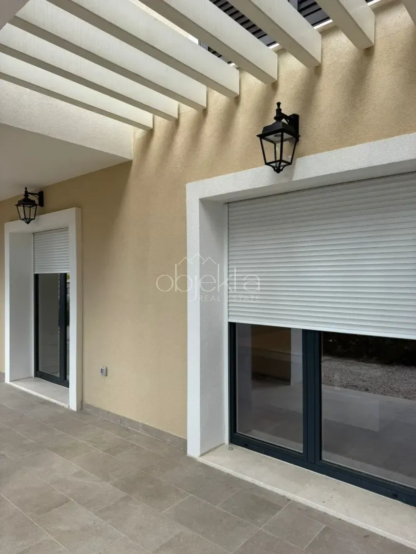 Covered terrace with outdoor lighting and window shutters.