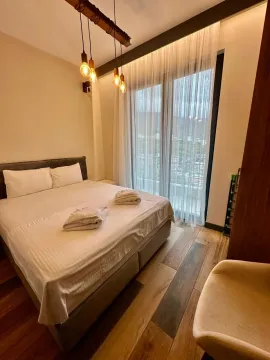 Modern bedroom with a double bed, wooden flooring, and balcony access. - image 6