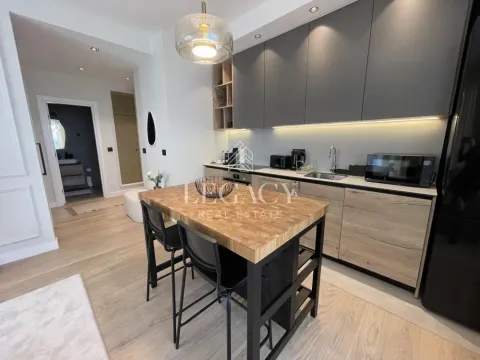 Modern kitchen with a wooden island and built-in units. - image 7