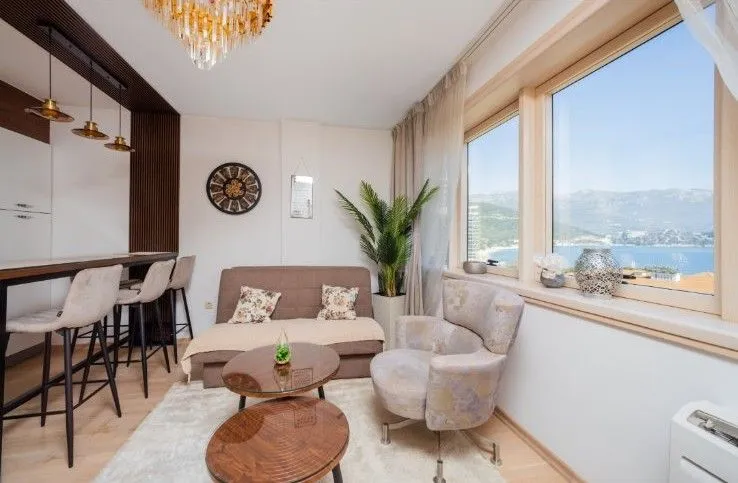Dnevni boravak sa garniturom, trpezarijskim dijelom i pogledom na more.