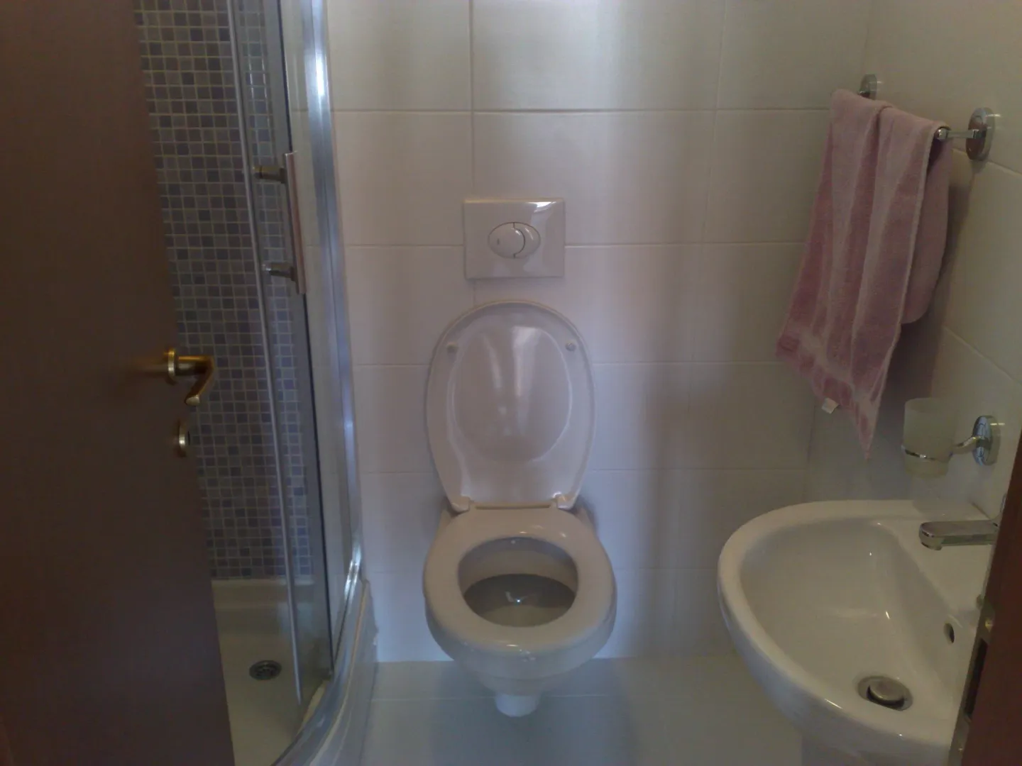 Malo kupatilo sa tuš kabinom, toaletom i umivaonikom.
