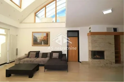 Spacious living room with a sofa, fireplace, and high ceilings with a gallery. - image 3
