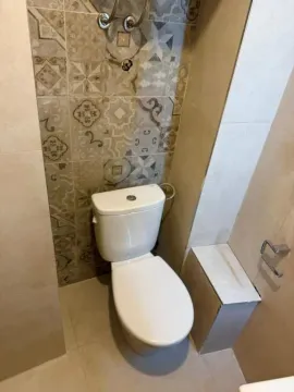 View of a modernly equipped bathroom with decorative tiles. - image 9