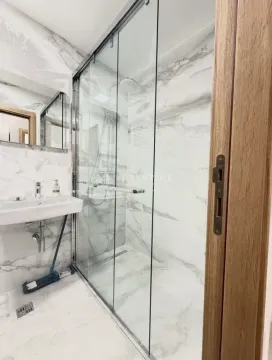 Modern bathroom with a walk-in shower and marble tiles. - image 9