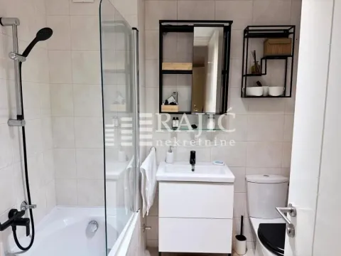 Modern equipped bathroom with a bathtub and a washbasin. - image 11