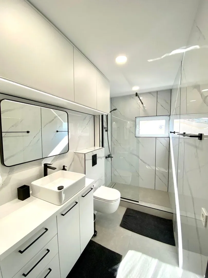 Modern and tidy bathroom with white fittings and a walk-in shower.