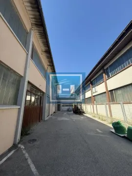 View of the exterior of an industrial facility with a passageway between buildings. - image 23