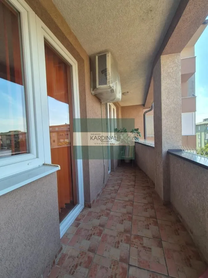 Dugački popločani balkon sa klima uređajem i spoljnim prozorima stanova.