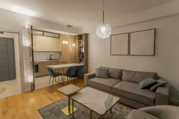 Living room with a sofa and dining area in the background.